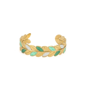 Close-up of gold stainless steel leaf bracelet with green and white enamel details