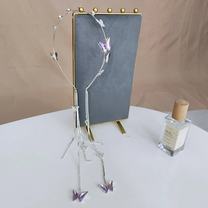 Detailed view of a silver headband featuring purple crystal butterflies and long tassels