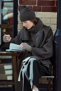Detail of coffee brown knitted scarf and gloves set with a stylish matching cardigan