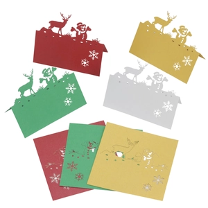 Laser-cut Christmas table cards featuring reindeer and snowflake designs in multi-colors