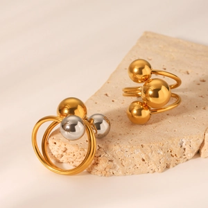 Minimalist polished stainless steel triple bead rings in gold and silver finish on stone