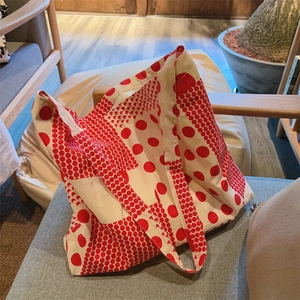 Détail du sac fourre-tout en toile à pois rouges avec de larges bretelles confortables