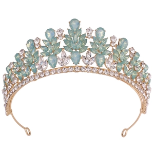 Detail of vintage gold crown with green opal crystals and sparkling rhinestones