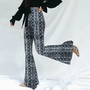 Detail shot of high-waisted flare pants featuring a grey and white snakeskin print pattern