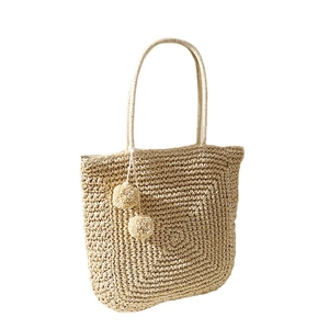 Handmade beige straw tote bag with cute pompom charms and woven shoulder straps