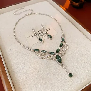 Elegant silver jewelry set with green marquise stones and crystal tassel fringe