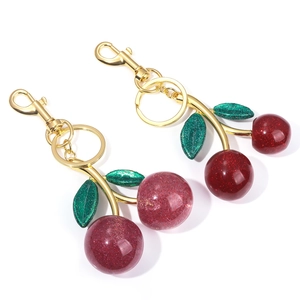 Detail of red resin cherry keychains with glitter filling and golden lobster clasp