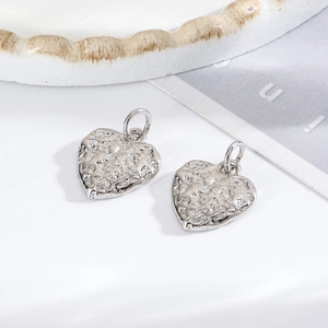 Macro view of textured silver heart pendants for DIY bracelets and necklaces jewelry