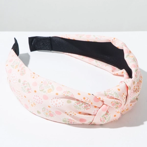 Detail of pink floral fabric knotted headband with delicate flower and dot patterns