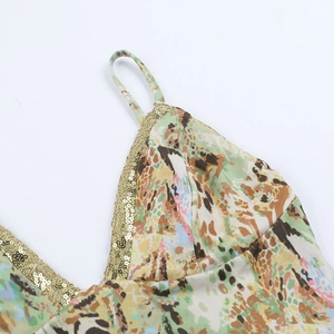 Detailopname van sexy bikini-topje met gouden pailletten en abstracte dierenprints op wit