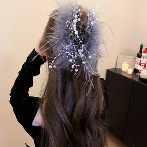 Detail showing elegant grey faux feather and pearl beads on a large hair claw clip