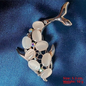 Macro detail of rose gold dolphin brooch with cat eye stones and rhinestones, size 5.3cm