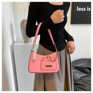 Detail of pink PU leather shoulder bag with gold zipper and decorative chain on a model