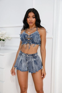 Detailansicht der ausgefransten Fransen und gewaschenen Denim-Struktur auf blauen Rüschenshorts