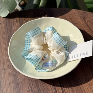 Detail of scrunchie with West Highland Terrier embroidery and blue checkered trim on tray