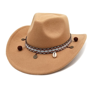 Detail of western wool fedora hat featuring bohemian woven band with shell and pompom charms
