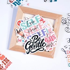 Close-up of holographic inspirational vinyl stickers displayed in a wooden frame