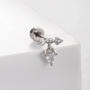 Clou d'oreille en acier titane avec cristal cœur sur support géométrique blanc
