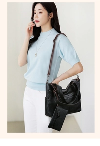 Detailed view of large black lychee textured tote bag with dark brown strap on a model