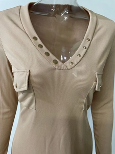 Détail de la texture maille côtelée sur la robe à manches longues et boutons dorés