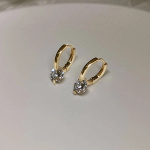 Detail view of S925 silver stud earrings with gold finish and round clear sparkling stones
