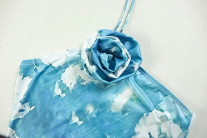 Detail of blue and white marble print dress featuring a 3D floral rose and thin straps