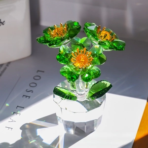 Detailed view of faceted green crystal flowers in a clear hexagonal glass vase decor
