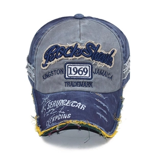 Detail of washed denim baseball cap with vintage frayed edges and 1969 embroidery