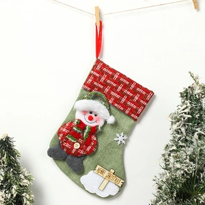 Close-up of green burlap Christmas stocking with snowman doll and Merry Christmas wood sign