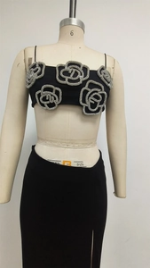 Detail of black two-piece set featuring large silver rhinestone camellia flowers and side slit