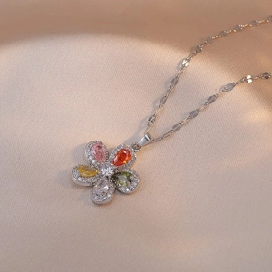 Collier élégant en argent avec fleur en zircone colorée sur fond de soie champagne