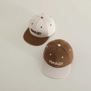 Dettaglio del ricamo Hello smiley sul cappellino hip hop bicolore per bambini