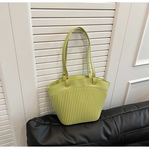 Detail of green pleated crossbody bag with golden metal rings and leather texture