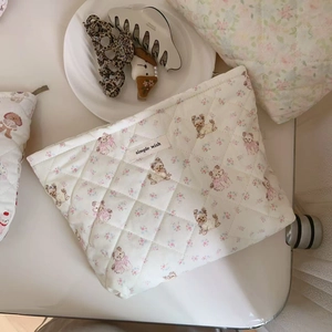 Detailed close-up of quilted floral cosmetic bag with dog print and simple wish label