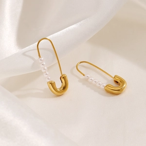Retro gold-plated paperclip earrings with imitation pearls on white satin background