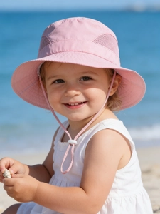Close-up of pink sun hat's breathable mesh window and adjustable chin strap on beach