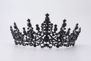 Detailed close-up of a luxurious black crystal crown with intricate metal floral patterns