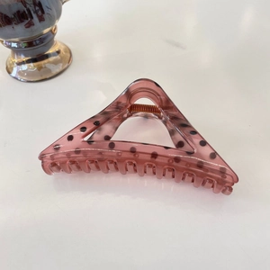 Detail of purple translucent triangle hair claw clip with stylish black polka dots