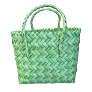Handmade green and white woven basket bag with dual handles for gifts and beach use