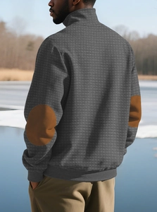 Makro-Detail des dunkelgrauen Waffelstrick-Sweatshirts für Herren mit Ellenbogen-Patches