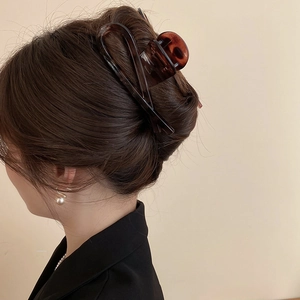 Detail view of large amber leopard print claw clip on hair for elegant styling
