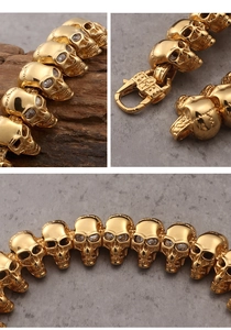 Detail of gold skull bracelet with clear crystal eyes and secure lobster clasp closure
