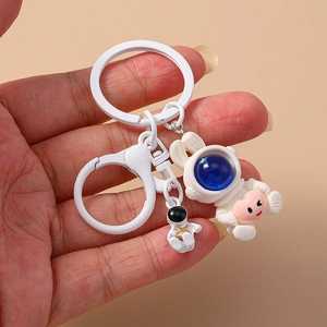 Cute astronaut keychain set with pink heart and gold star charms on white metal ring