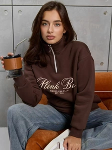 Détail de l'imprimé Urban Vibe Club sur le sweat à col zippé marron et texture du tissu