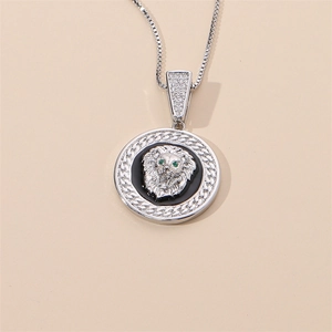 Vue macro du pendentif tête de lion en argent avec yeux verts sur émail noir