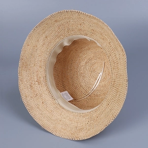 Détail intérieur d'un chapeau de soleil en raphia tissé avec bandeau et cordon ajustable