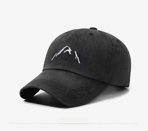 Detail view of the embroidered white mountain peak on the washed cotton baseball cap