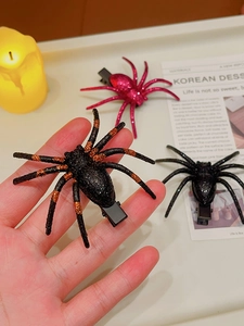 Close-up of spooky spider hair clips in black, orange, and rose red glitter styles