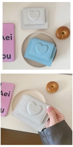 Close-up of heart-embossed PU leather wallets in white and blue colors