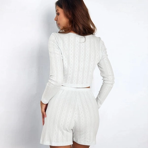 Detail view of the back of a white knitted two-piece set with hollow vertical stripes